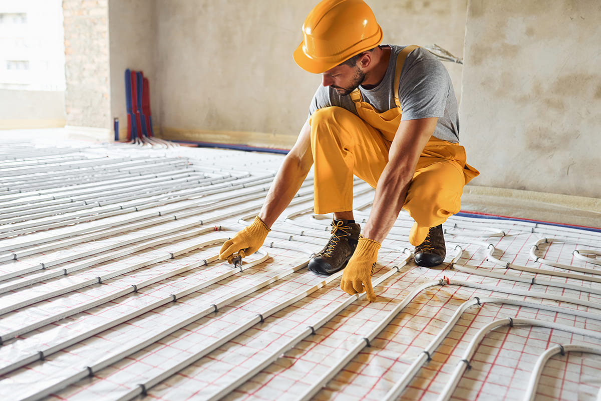 worker-yellow-colored-uniform-installing-underfloor-heating-system